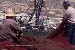 Image du Maroc Professionnelle de  Quelques ouvriers s'activent à réparer les filets de pêche sur un des quais au port d'Agadir, ville située au sud du Maroc, Vendredi 23 Août 2002. (Photo / Abdeljalil Bounhar)

 